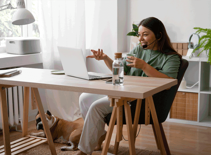 Uma mulher sentada à mesa com um laptop