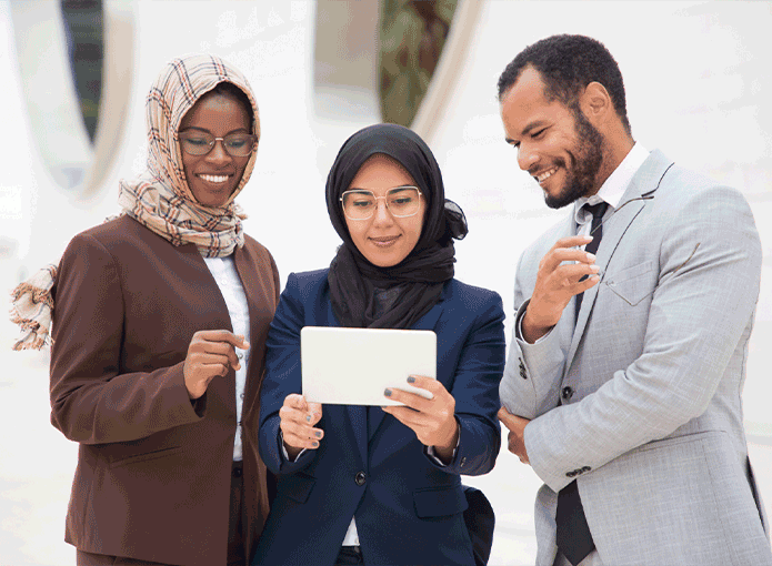 Três pessoas de etnias diferentes olhando para um tablet