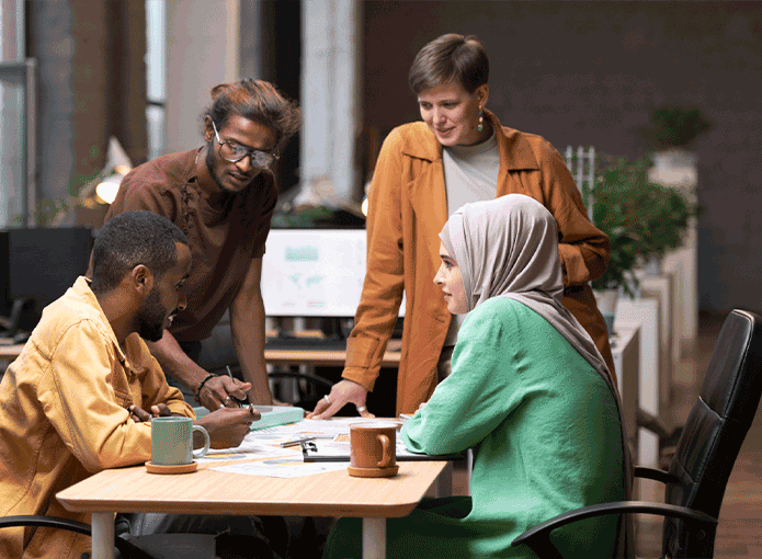 Pessoas de etnias diferentes em volta de uma mesa de trabalho