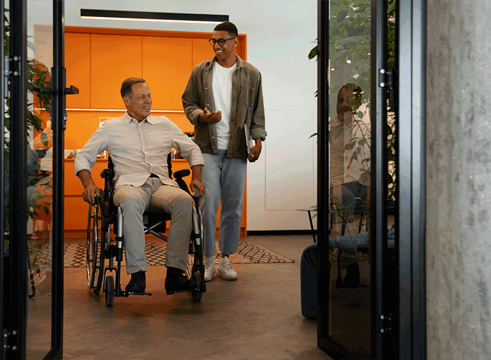 Um homem em uma cadeira de rodas conversando com outro homem