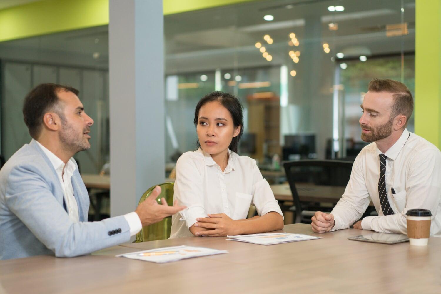 Profissionais conduzindo entrevista com foco em competências comportamentais no escritório