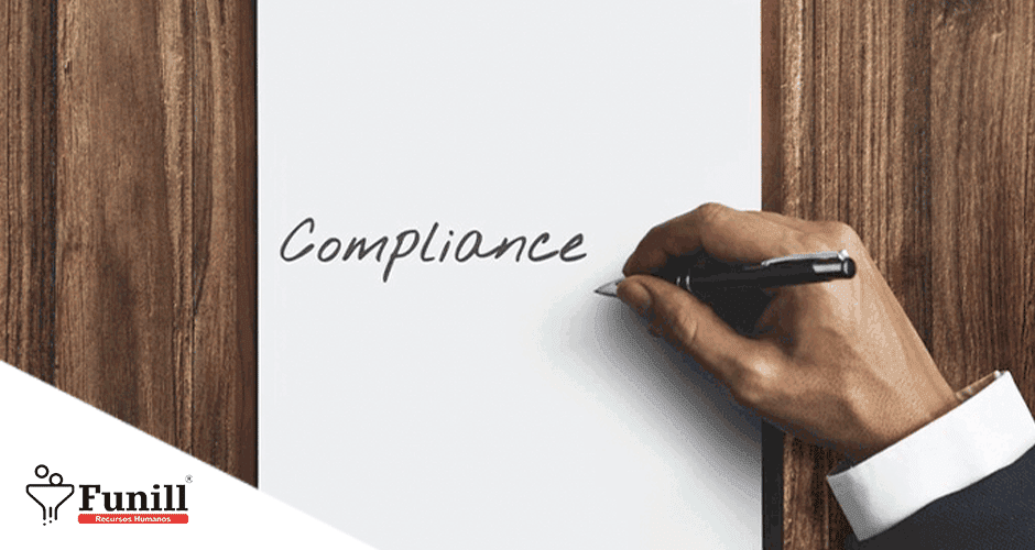 Mão de um homem escrevendo a palavra "Compliance" num papel